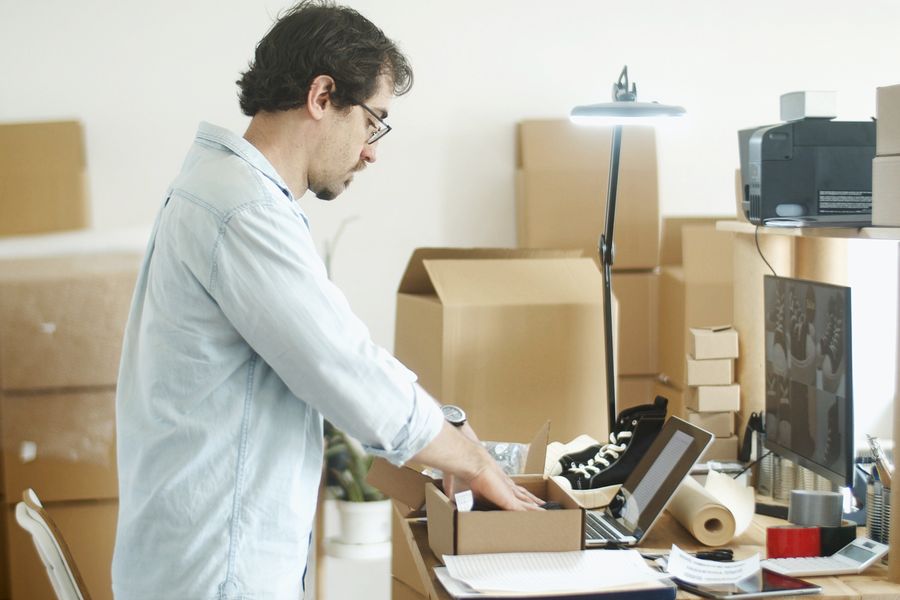Person holding cardboard box on table